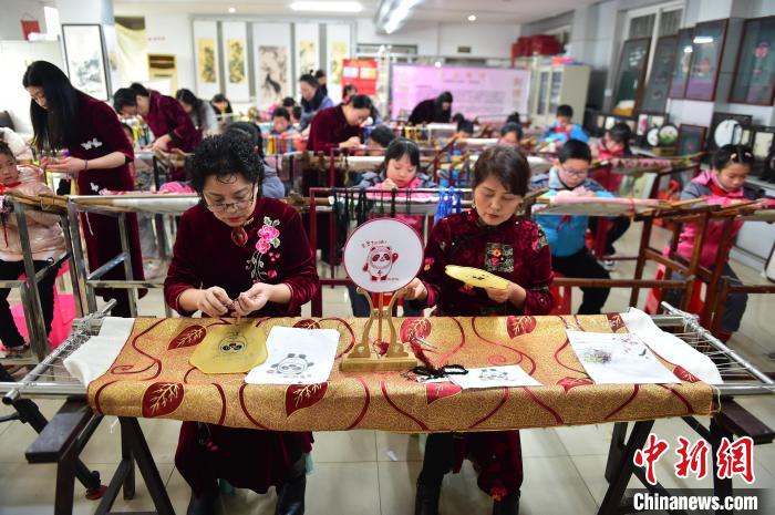 江西省級非遺豫章繡傳承人手把手指導(dǎo)小學(xué)生繡制2022年北京冬奧會吉祥物“冰墩墩”形象?！∮髟屏?攝