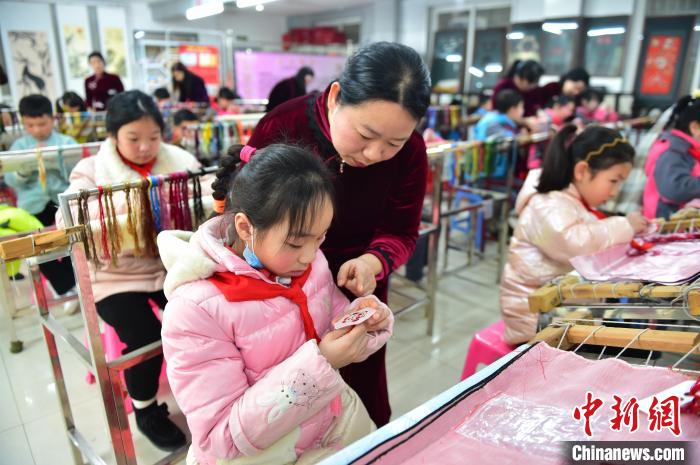 江西省級非遺豫章繡傳承人手把手指導(dǎo)小學(xué)生繡制2022年北京冬奧會吉祥物“冰墩墩”形象?！∮髟屏?攝