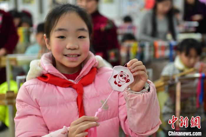 圖為一名小學(xué)生繡制的2022年北京冬奧會吉祥物“冰墩墩”形象?！∮髟屏?攝