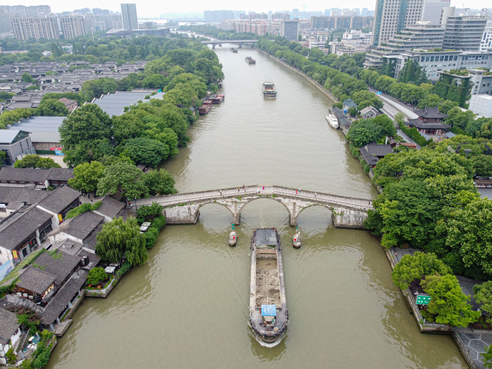 5月27日，一艘貨船駛過京杭大運河南端標(biāo)志建筑杭州拱宸橋。(無人機照片)新華社記者江漢 攝