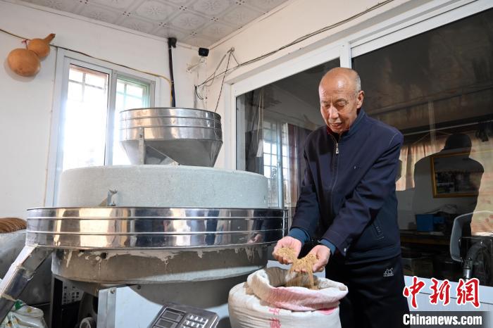 李家莊村民谷文朝重拾父輩的手藝，做起石磨面粉的營生?！〉杂鸺?攝