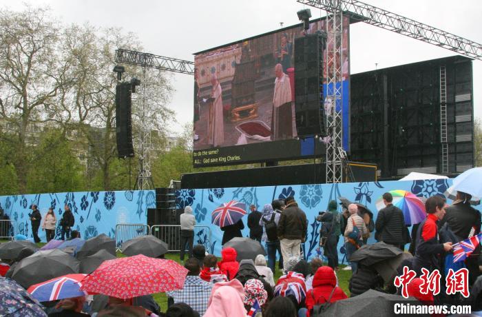 當(dāng)?shù)貢r間5月6日，英國國王查爾斯三世的加冕儀式舉行。民眾雨中觀看儀式。　歐陽開宇 攝