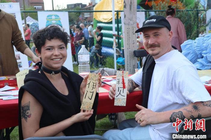 當(dāng)?shù)孛癖娫跐h字體驗工作坊展示自己手寫的中文名書簽。　魯汶孔子學(xué)院供圖