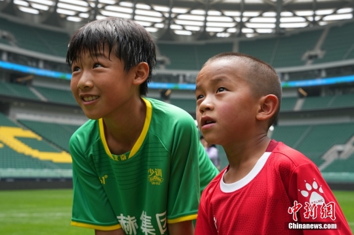 圖為北京國安小球員陳小北和7歲的俄金仁增在一起觀看場內播放的紀錄片。<a target='_blank' href='/' _fcksavedurl='/'><p  align=