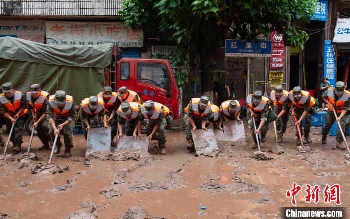7月4日，萬州區(qū)五橋街道，武警官兵清理街道上的淤泥?！∪矫宪?攝