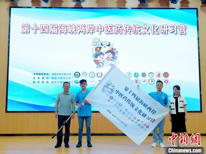 共青團福建省委副書記吳雪(右一)、福建中醫(yī)藥大學黨委副書記林羽(左一)為兩岸學生代表頒授營旗?！≡S燁婷 攝