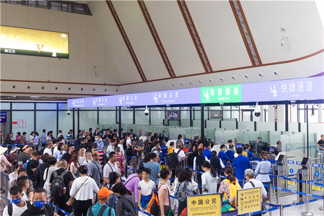 7月22日，乘坐中老鐵路國際旅客列車的旅客在磨憨邊檢大廳排隊(duì)候檢。衛(wèi)海林 攝