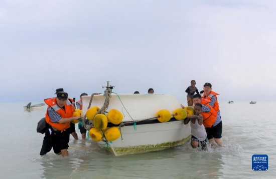 7月21日，中國(guó)海軍“和平方舟”號(hào)醫(yī)院船醫(yī)護(hù)人員涉水登島，前往基里巴斯一診療點(diǎn)。新華社記者 黎云 攝