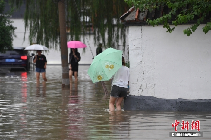 7月31日，市民行走在雨中的北京房山區(qū)瓦窯頭村。北京市氣象臺當日10時發(fā)布分區(qū)域暴雨紅色預警信號。北京市水文總站發(fā)布洪水紅色預警，預計當日12時至14時，房山區(qū)大石河流域將出現(xiàn)紅色預警標準洪水。<a target='_blank' href='/'><p  align=