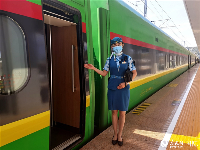 趙瑩靜站在“復(fù)興號(hào)”國(guó)際旅客列車車廂門口歡迎旅客上車。人民網(wǎng) 杜明明攝