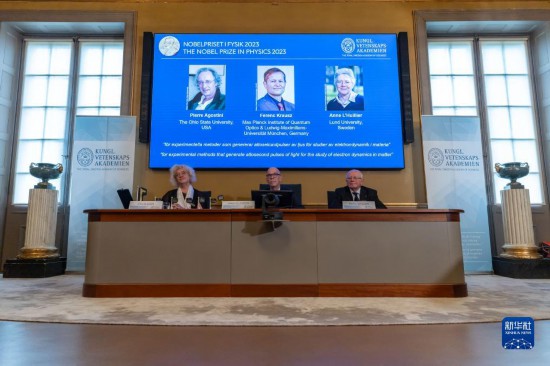 10月3日，在瑞典斯德哥爾摩舉行的2023年諾貝爾物理學獎公布現場，屏幕上顯示獎項得主皮埃爾·阿戈斯蒂尼（左）、費倫茨·克勞斯（中）和安妮·呂利耶的照片。新華社發(fā)（魏學超攝）