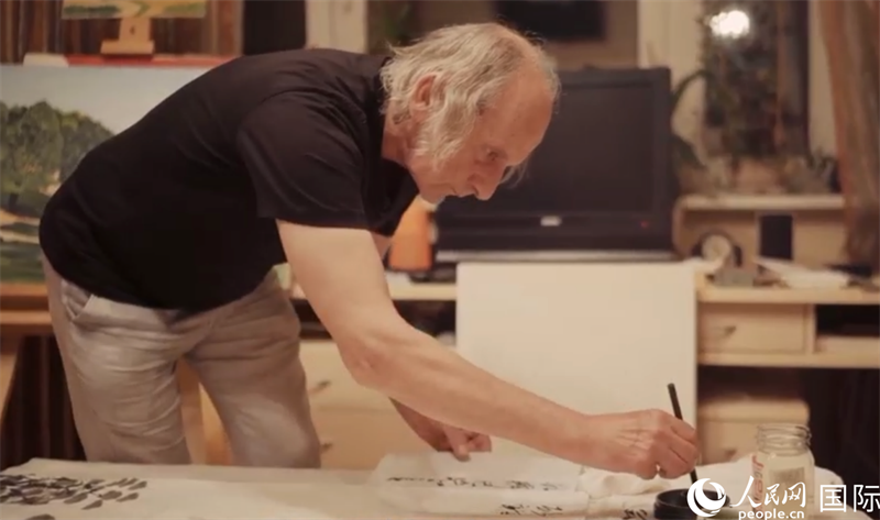 伊戈爾·布爾東諾夫在畫作上題詞。人民網(wǎng)記者 馬天翼攝