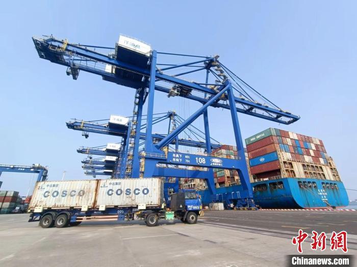 圖為海南洋浦國際集裝箱碼頭，卡車將集裝箱從后方堆場運往碼頭裝卸區(qū)?！堅潞?攝