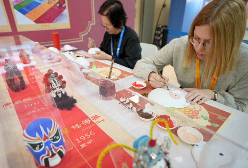 10月16日，在第三屆“一帶一路”國(guó)際合作高峰論壇新聞中心，來(lái)自比利時(shí)的記者（右）體驗(yàn)畫京劇臉譜。新華社記者 王毓國(guó) 攝