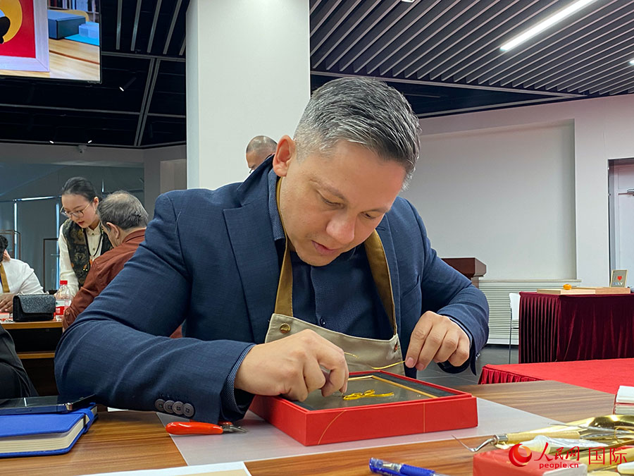 2023“一帶一路”媒體合作論壇聯(lián)合采訪團(tuán)團(tuán)員，親身體驗(yàn)景泰藍(lán)工藝。人民網(wǎng)記者 于洋攝