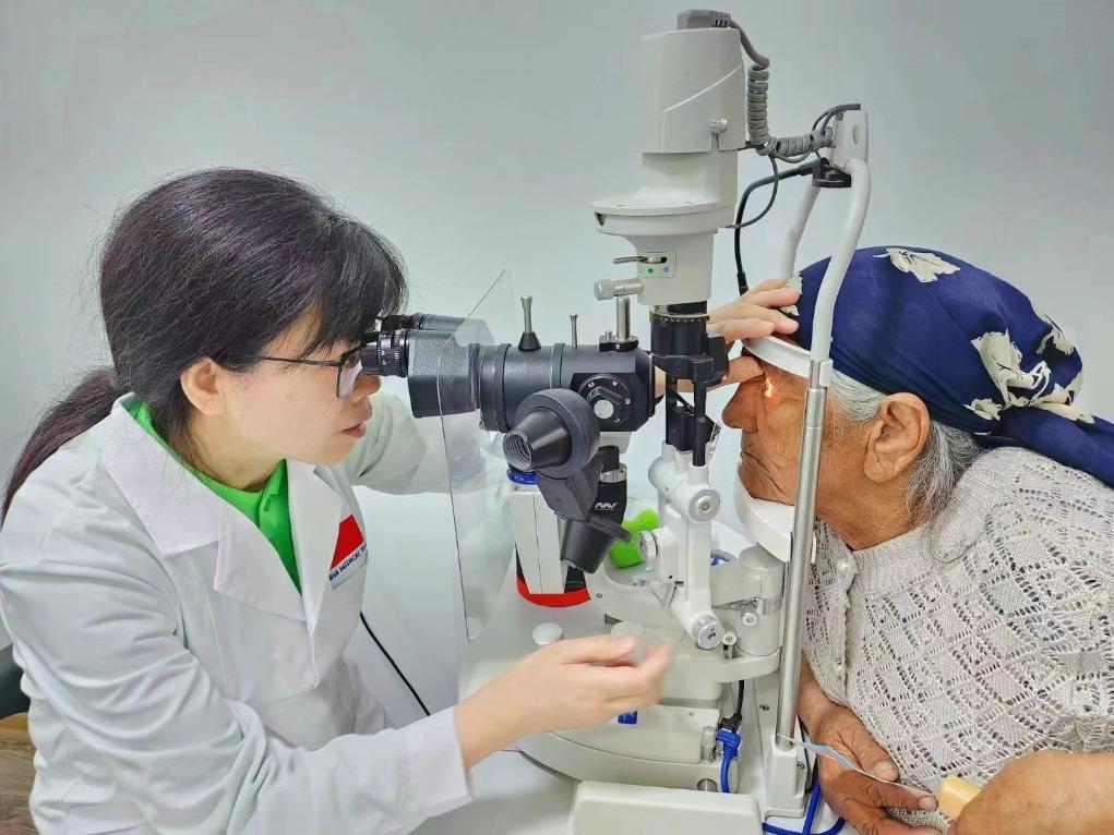 北京大學(xué)人民醫(yī)院眼科醫(yī)生鮑永珍正在為中亞白內(nèi)障患者進(jìn)行眼部檢查。（北京大學(xué)人民醫(yī)院供圖）