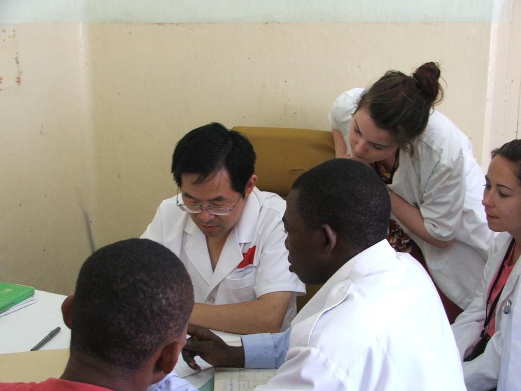 2011年7月22日，在坦桑尼亞桑給巴爾納茲莫加醫(yī)院外科門診，中國第24批援桑給巴爾醫(yī)療隊隊長盧建林為當(dāng)?shù)鼗颊咴\治并帶教實習(xí)生。新華社發(fā)（國家衛(wèi)生健康委供圖）