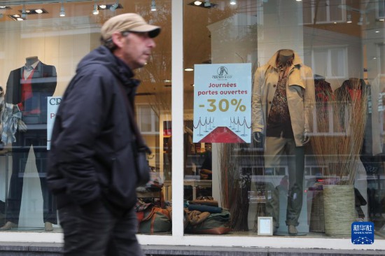   10月31日，一名男子從比利時布魯塞爾一家貼有打折信息的店鋪前走過。新華社記者 趙丁喆 攝