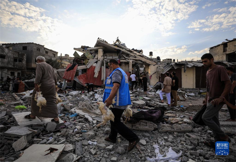 10月27日，在加沙地帶南部城市汗尤尼斯，人們經過以軍襲擊后的房屋廢墟。