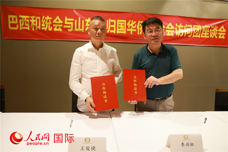 中國(guó)僑聯(lián)副主席、山東省僑聯(lián)主席李興鈺（右）與巴西和統(tǒng)會(huì)會(huì)長(zhǎng)王俊曉簽署合作協(xié)議書。人民網(wǎng)記者 陳海琪攝