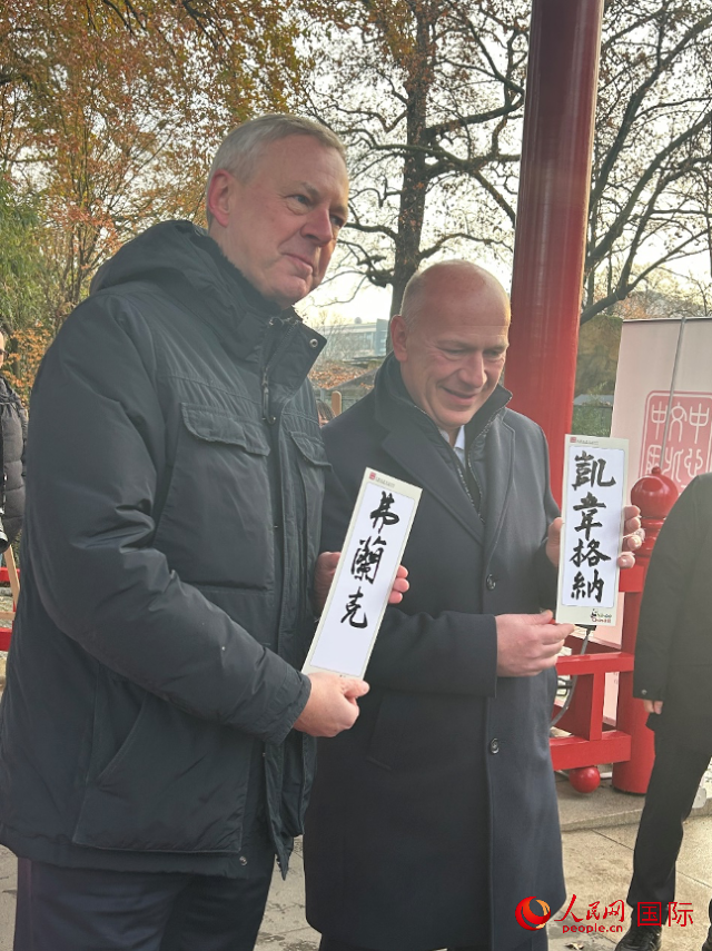 柏林市長韋格納（右）、動物園監(jiān)事會主席布魯克曼（左）手持中國文化中心工作人員現(xiàn)場手書的中文名字。人民網(wǎng)記者 徐馨攝