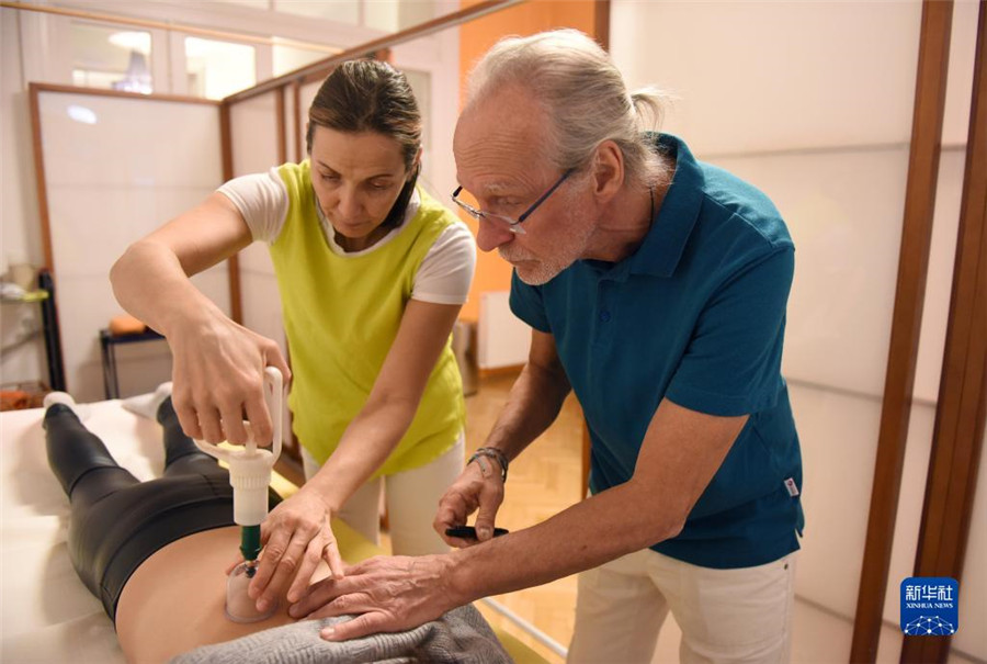 12月12日，在奧地利維也納，科格勒醫(yī)生（右）和助手在為病人進(jìn)行拔罐治療。新華社記者 賀燦鈴 攝