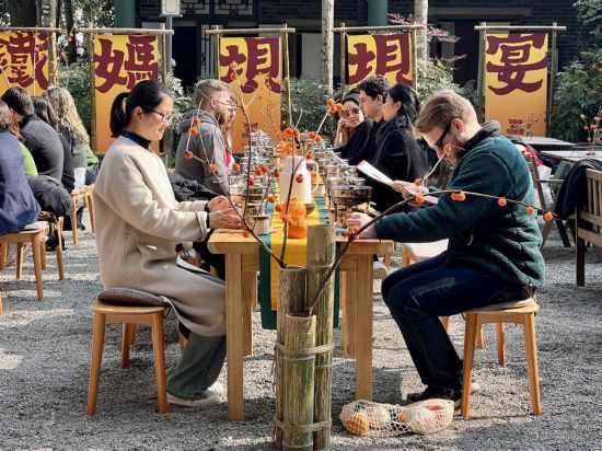 哥倫比亞大學青年學生代表團與蒲江縣鐵牛村村民一起交流、品嘗當地的小火鍋。