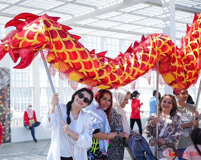 游客體驗(yàn)舞龍。 人民網(wǎng) 塔里克·易卜拉欣攝