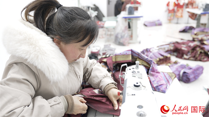 1月24日，在山東省菏澤市曹縣大集鎮(zhèn)云牧服飾有限公司，高燕正在縫制馬面裙。 人民網(wǎng)記者 袁蒙攝