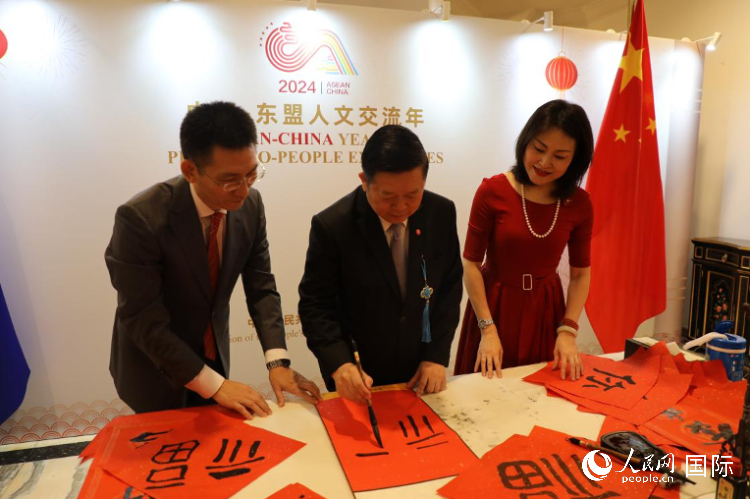 東盟秘書長高金洪（中）在活動現(xiàn)場寫福字。人民網(wǎng)記者曹師韻攝