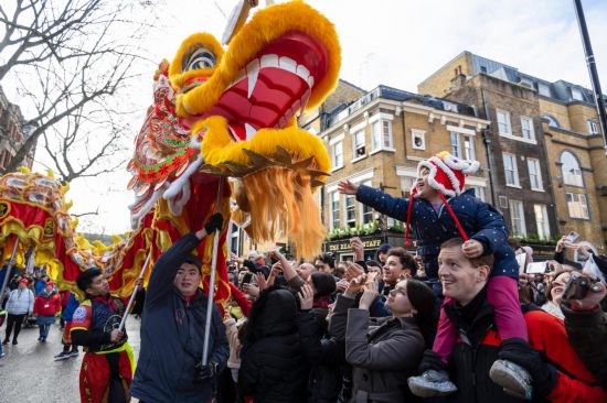 2月11日，人們在英國倫敦的新春巡游活動中觀看舞龍表演。新華社發(fā)（史蒂芬·程攝）