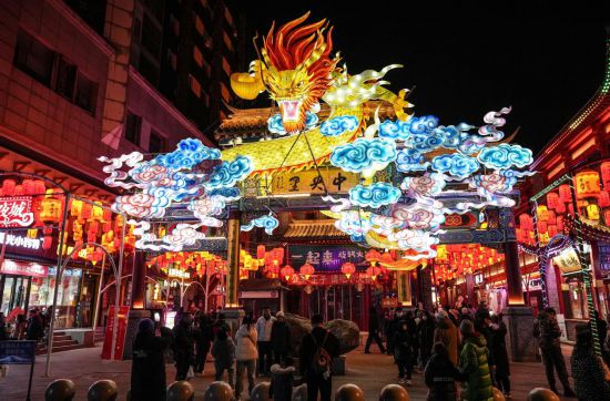 2月11日，游客在沈陽中街游覽。春節(jié)期間，各地?zé)艋痂病⒒饦溷y花，呈現(xiàn)出一幕幕流光溢彩的視覺盛宴。（新華社記者潘昱龍攝）