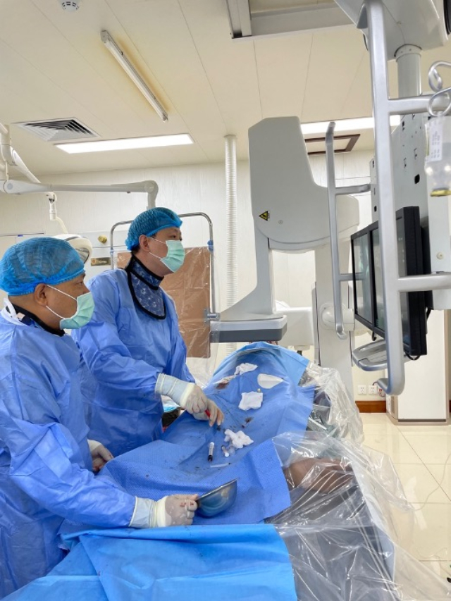 李凱教授（右）和劉海濤教授（左）為患者行TACE手術(shù)。中國駐老撾大使館供圖