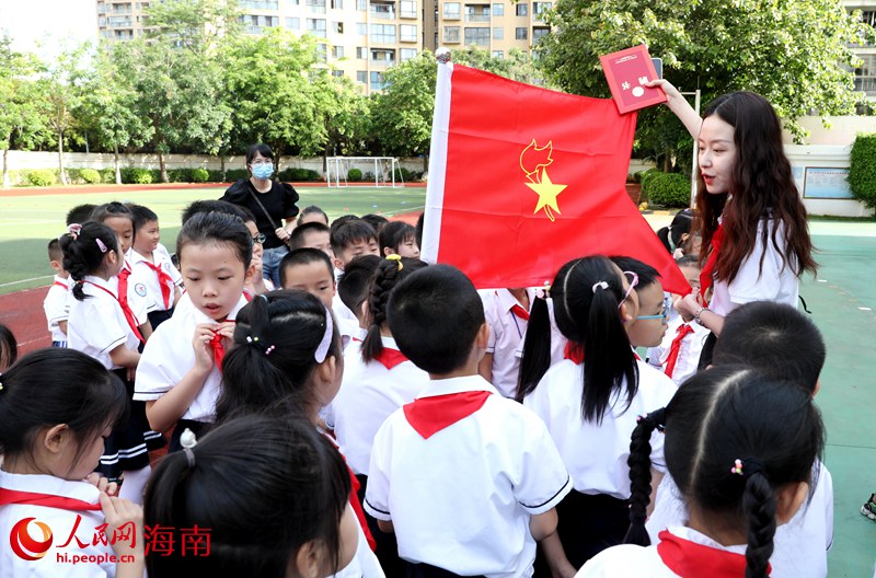 老師向少先隊員展示隊旗。人民網(wǎng) 符武平攝