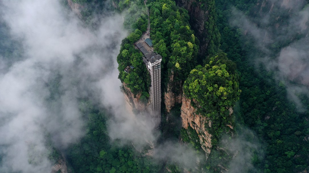位于張家界武陵源景區(qū)的百龍?zhí)焯蓁偳对谠旗F繚繞的峰林間，雄偉壯觀。吳勇兵攝