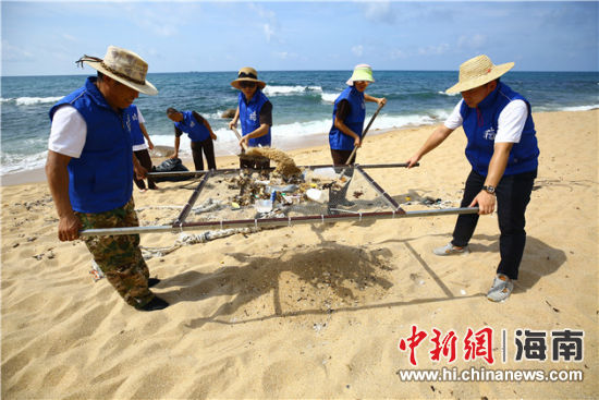 環(huán)保志愿者用篩網(wǎng)“淘”出海灘上的垃圾。