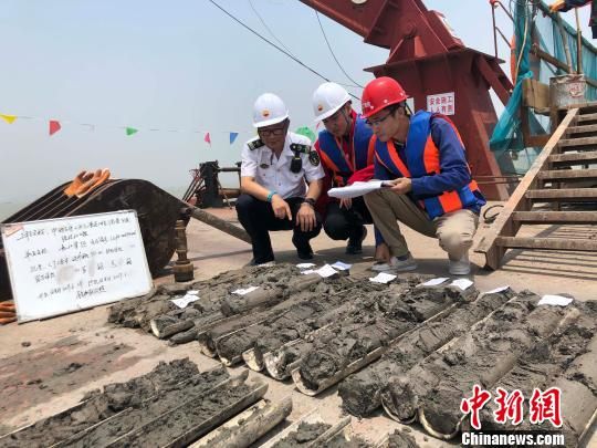 圖為勘察設(shè)計(jì)人員與海事局工作人員查看巖芯情況?！∥赫?攝