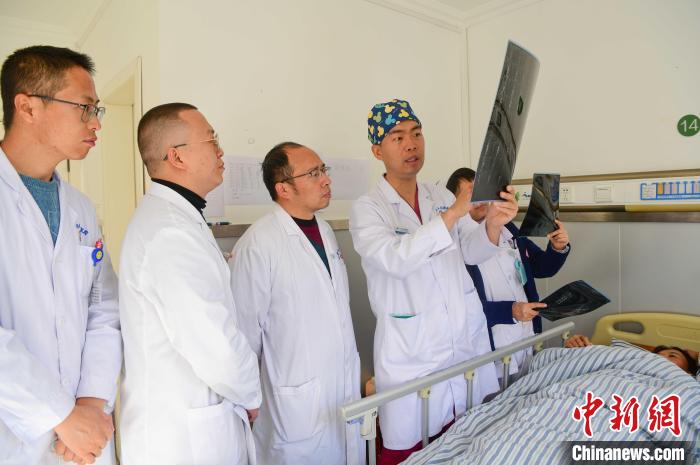 圖為何蔚副主任醫(yī)師(站右二)及團隊討論患者病情?！∝暩聛硭?攝