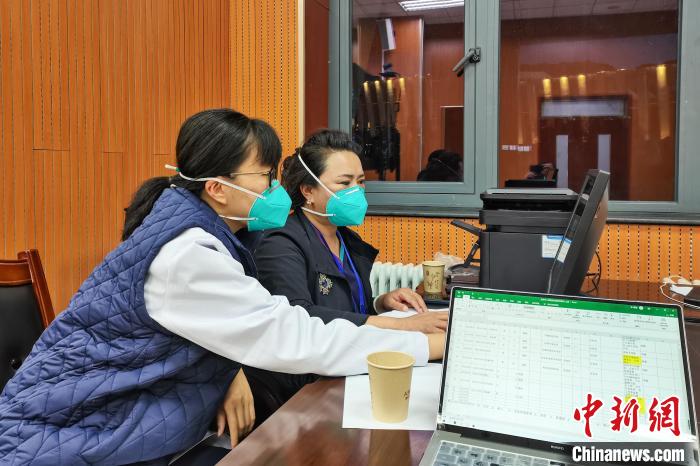 8月9日，楊蘇喬(左)在拉薩方艙醫(yī)院指揮部讀取艙內(nèi)患者胸部CT?！∈茉L者供圖