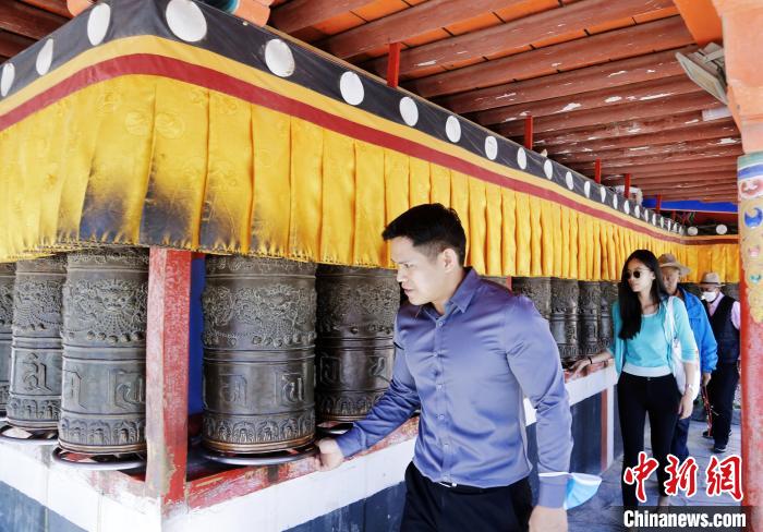 圖為外籍嘉賓體驗藏族傳統(tǒng)轉經(jīng)筒。　馬銘言 攝