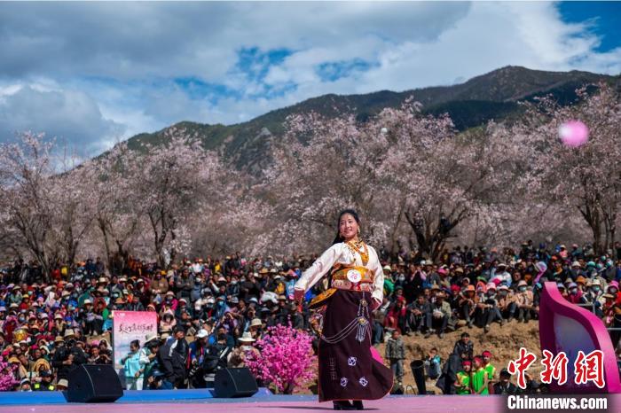 桃花林下精彩的“桃花仙子”選拔吸引村民或游客。　劉忠俊 攝