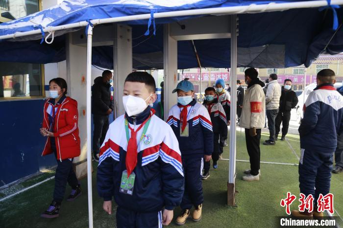 圖為學生測量體溫后進入校園?！●R銘言 攝