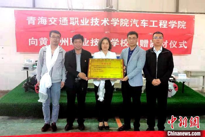 圖為李富香(中)代表學(xué)校為州縣技校捐贈(zèng)器材。(資料圖) 青海省教育廳供圖