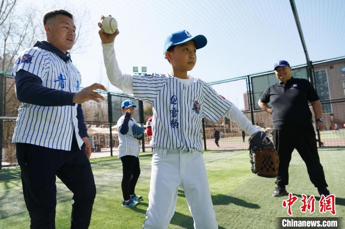 圖為教練指導(dǎo)小棒球手?jǐn)S球技術(shù)?！●R銘言 攝