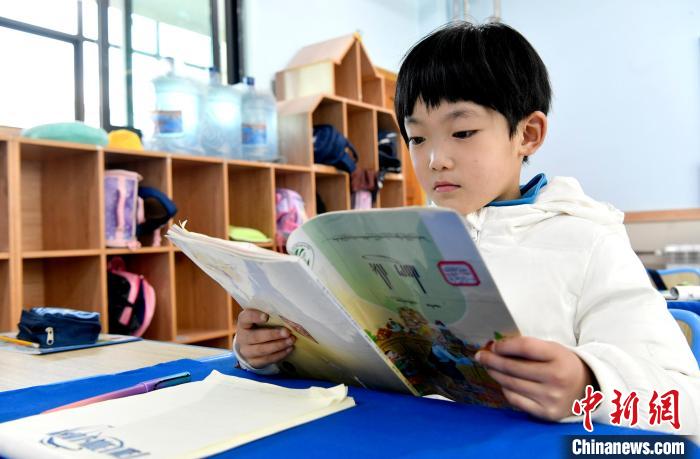 3月14日，西藏拉薩市第一小學(xué)一年級六班學(xué)生丁增樂吉在閱讀藏語課本。　李林 攝