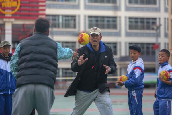 在高原上教孩子們打手球，“慢慢兒來，甭著急！”