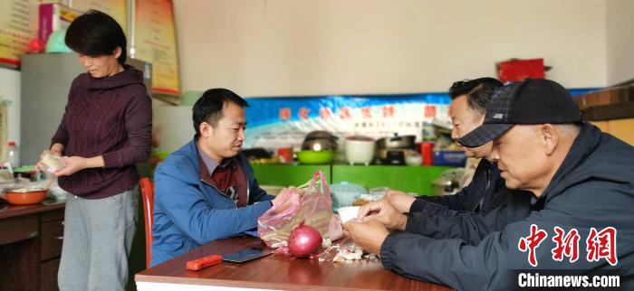 圖為扶貧路上“臨時一家人”準(zhǔn)備午餐?！∥航ㄜ?攝
