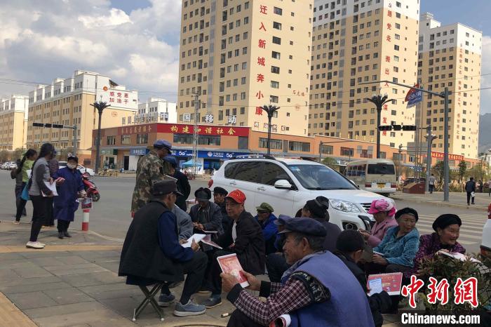 圖為會(huì)澤縣城易地扶貧搬遷安置點(diǎn)內(nèi)，老人們聚在廣場(chǎng)上聊天，身后是他們的新家?！】姵?攝