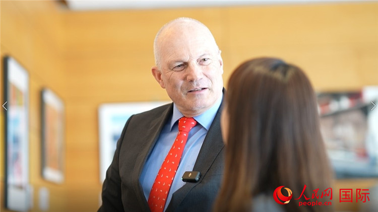 瑞士駐華大使白瑞誼介紹使館內(nèi)陳列的照片。人民網(wǎng) 彭昱凱攝