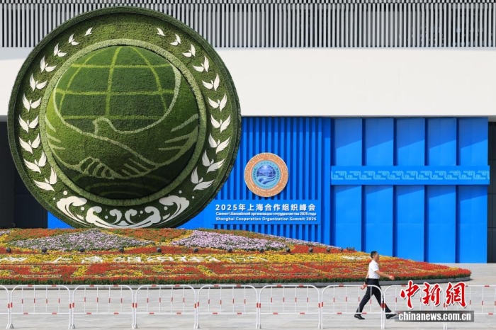 8月31日，天津，一名工作人員從2025年上海合作組織峰會主會場外的景觀花壇旁經(jīng)過。當(dāng)日，2025年上海合作組織峰會在天津舉行。<a target='_blank' href='/'><p  align=